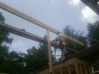 Carpenter setting a ridge beam over a new addition frame — Ice Dam Removal by Roofing Brothers in Schuyler