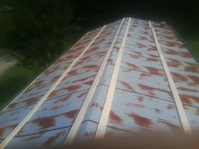 Rusted metal roof panels with new wood purlins before replacement — Storm Damage Roof Repair in Schuyler by Roofing Brothers